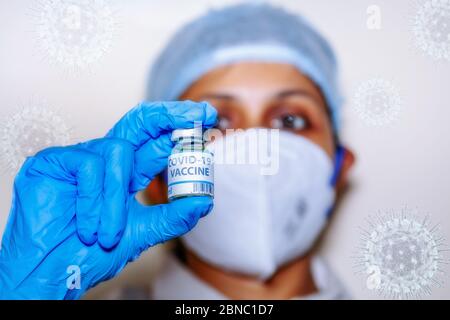 Coronavirus conceptual image of Indian nurse holding a vaccine bottle used for treating Covid-19 patients Stock Photo