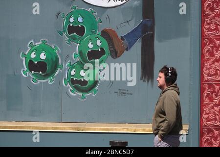 A man walks past a coronavirus mural outside Devitts Pub on Camden Street, Dublin. Stock Photo