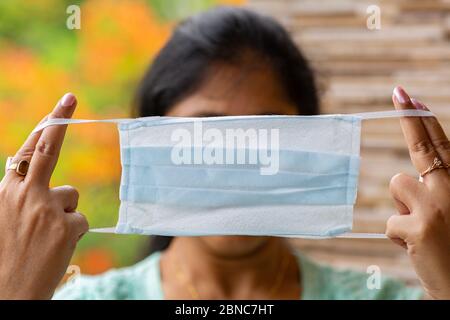 Indian woman holds a face mask before wearing as a corona virus preventive concept