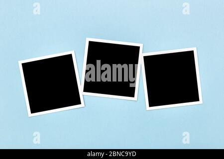 Blank empty vintage photo frames templates on blue background. Instant photos mockup. Flat lay Stock Photo