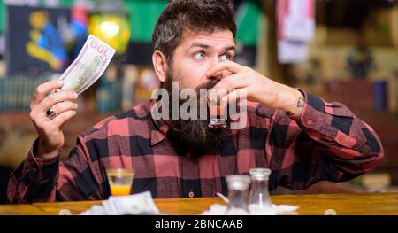 Visitor giving cash, dollar banknote to bartender to pay for drinks. Man drinking cocktail and asking for more drinks Stock Photo