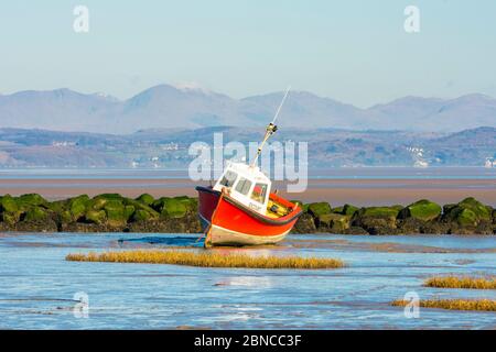 Fishing boat at low tide, Morecambe, with the Coniston Fells in the Lake District behind Stock Photo