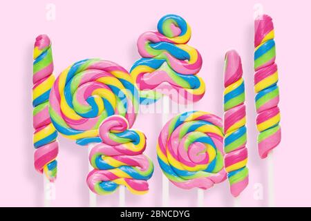 Colored lollipops of different shapes on a pink background. Sweet, beautiful and trendy sweets Stock Photo