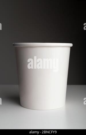 White paper coffee cup on table on dark background Stock Photo
