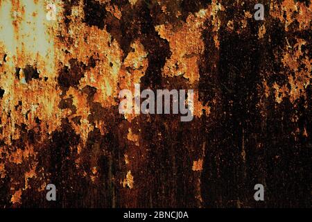 Dark metal background with rust. Rusty peeling paint on the garage door closeup. Texture of a rusty metal surface. Stock Photo