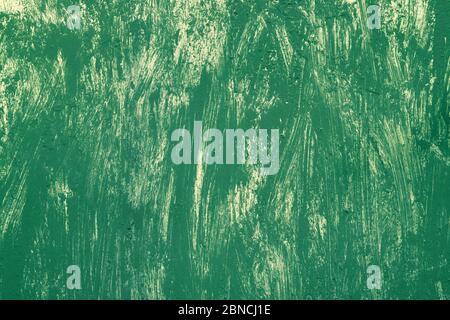 Green background with yellow dry brush strokes. Metal painted surface. Texture of green and yellow paint, chaotic dry brush strokes. Stock Photo