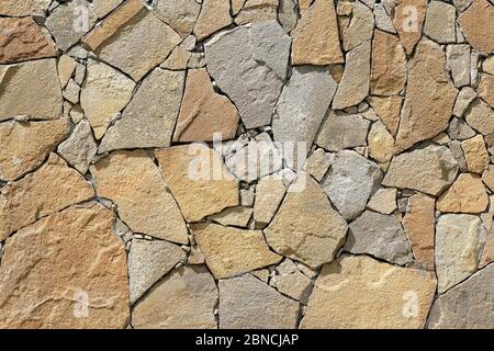 Texture of masonry closeup. Stones of different sizes on the wall, decoration of the facade of the house. Abstract brown rock pattern. Facing the faca Stock Photo