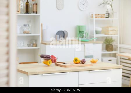 Image of kitchen table with wooden cutting board and fresh vegetables on it in the kitchen Stock Photo