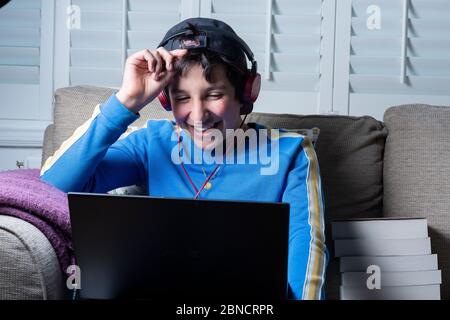 Teenage boy, 13, watches funny videos online on his laptop,UK Stock Photo