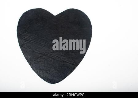 Black stone slate serving plate heart shaped, isolated on white background. Simple, no ingredients, space for copy text Stock Photo