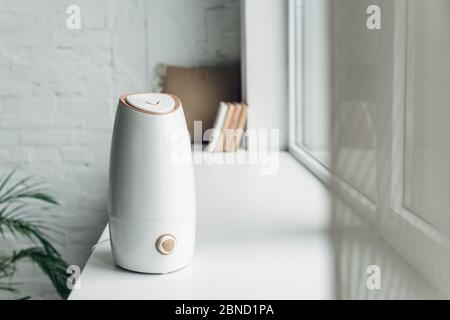 white ultrasonic purifier standing on windowsill at home Stock Photo