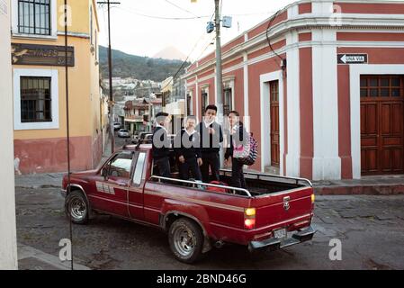 Happy school children getting a ride home in the back of a pick-up truck. Daily living in Quetzaltenango, Guatemala. Mar 2019 Stock Photo