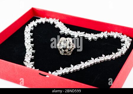 Close-up  of white gold chain and gemstone ring in gift box ready for valentine's day gift on white  background . Stock Photo