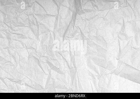 White wrinkled creased paper texture. Blank crumpled grainy paper textured surface. Smudged grungy grey poster. Close up. Material tissue for packing. Stock Photo