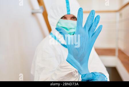 Nurses or medical professionals wearing protective clothing put on new disposable gloves during the Covid-19 epidemic Stock Photo