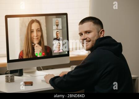 A fellow distracted and smiles from an online briefing at home. Stock Photo