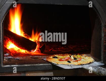 Handmade pizza in wooden oven Stock Photo