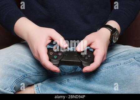 White man playing video games at home with a joystick in his hand stay at home concept Stock Photo