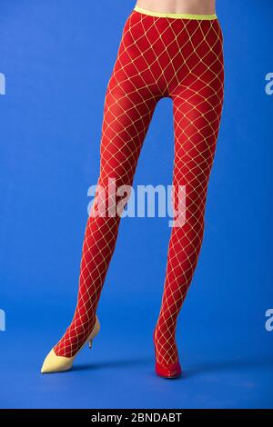 cropped view of model in fishnet tights and red heels posing on blue Stock  Photo - Alamy