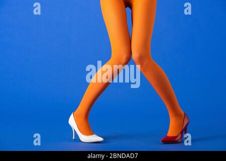 cropped view of woman in bright orange tights posing on blue Stock Photo -  Alamy