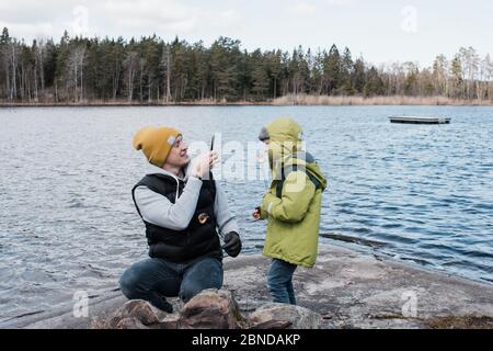 father taking pictures of his son whilst eating marshmallows Stock Photo