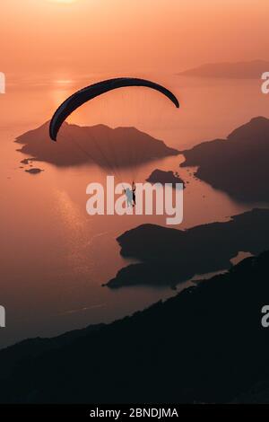 Paragliding at sunset over Blue Lagoon In Oludeniz, Turkey Stock Photo