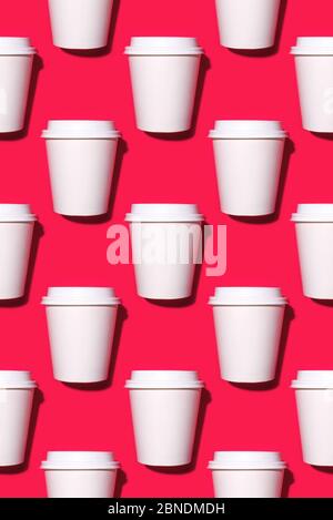 Pattern of disposable coffee cups on a red background. Stock Photo