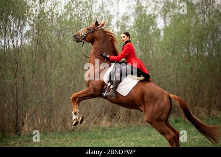 Woman jockey performs candle trick on horse racetrack Stock Photo