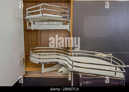 Interior design decor of kitchen in luxury apartment showing closeup detail of sliding carousel corner cupboard with shelves Stock Photo