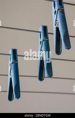 Close-up of plastic clothes pegs on Clothes Dryer Stand. A group of clothespins hanging on empty linen bars. Shooting from the bottom up. Selective fo Stock Photo