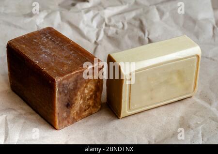 Various pieces of laundry soap on a plain background. Two rectangular pieces of new soap. Natural hygiene products. Place for text. Selective focus. Stock Photo