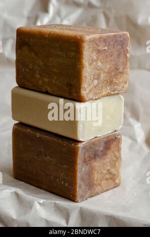 A stack of laundry soap on a beige background. Three different Rectangular pieces of new soap. Natural hygiene products. Place for text. Selective foc Stock Photo