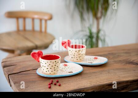 colorful handmade ceramic cups on wooden table Stock Photo