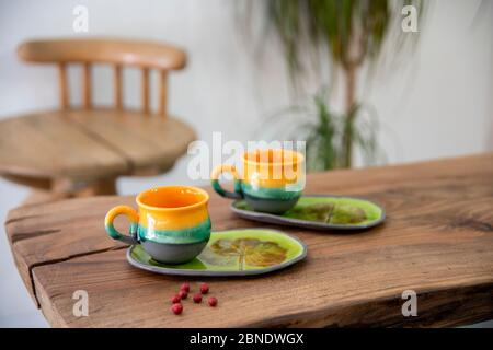 colorful handmade ceramic cups on wooden table Stock Photo