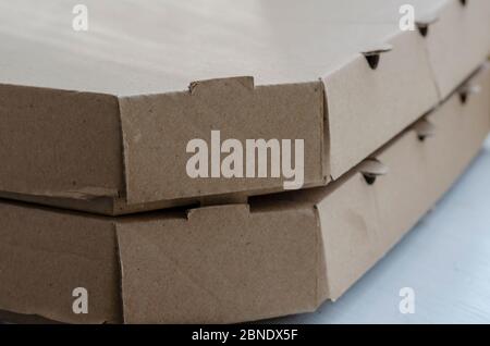 Cardboard boxes for pizza close-up. Two closed brown boxes in a stack. Food packaging and delivery. Courier service. Close-up. Selective focus. Stock Photo