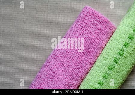 Soft multi-colored towels on a white textured background. Colorful bath towels. Health and hygiene care. View from above. Place for text. Stock Photo