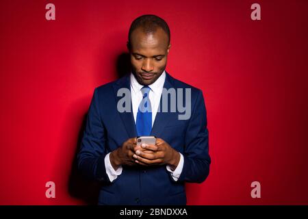 Portrait of his he nice attractive focused guy holding in hands using cell chatting corporate app 5g service solution wearing tux tuxedo isolated over Stock Photo