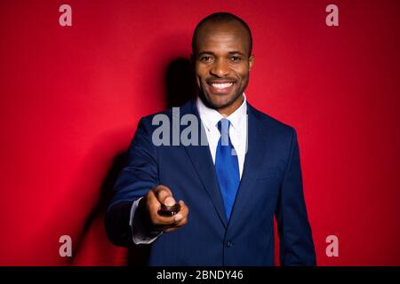 Close-up portrait of nice attractive cheerful guy holding in hands car key signal pushing button lock open sale discount dealer isolated over red Stock Photo