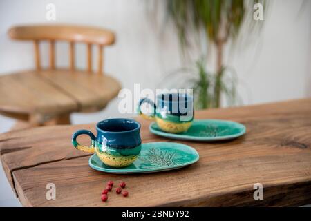 colorful handmade ceramic cups on wooden table Stock Photo