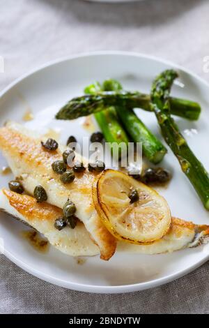 Lemon sole with butter and capers sauce and asparagus Stock Photo