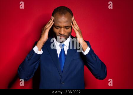Close-up portrait of his he nice attractive depressed overworked guy employer touching temples feeling bad spasm burn-out isolated over red maroon Stock Photo