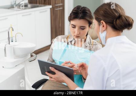 A doctor with her patient in the dentistry office, using a table Stock Photo