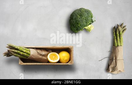 asparagus, broccoli and lemon on a white chalk background Stock Photo