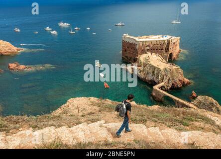Berlenga island, Portugal - July 09, 2017: Young man with backpack walking down the access path to Fort St. John the Baptist of Berlengas, on the isla Stock Photo
