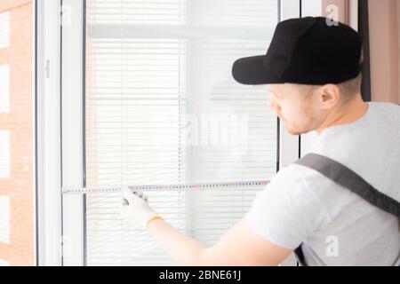 Master worker measures upvc window with ruler, installation process Stock Photo