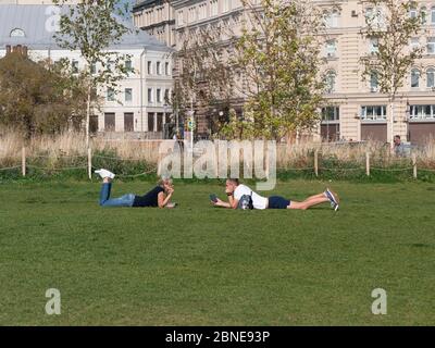 MOSCOW RUSSIA- AUG 25, 2018: Loving couple lying on the grass next to each other looking into the eyes Stock Photo