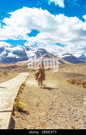 Incognito rider on horseback en route to the Pastoruri glacier, in the Huascarán National Park, Huaraz / Peru. Tropical glacier at 5200 meters above s Stock Photo