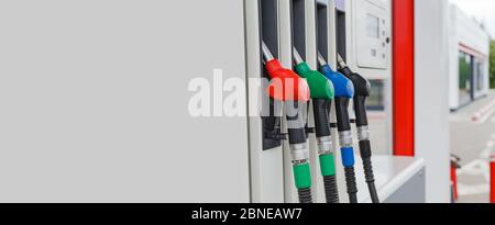 Virious colored refueling pistols or fuel guns in fuel column on fuel station with copy space. Fuel guns installed in to nests. Stock Photo