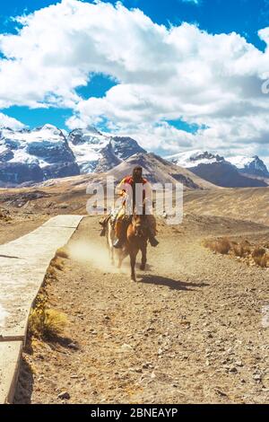 Incognito rider on horseback en route to the Pastoruri glacier, in the Huascarán National Park, Huaraz / Peru. Tropical glacier at 5200 meters above s Stock Photo