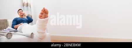 Man With Fracture Cast Recovering From Broken Leg Injury Stock Photo